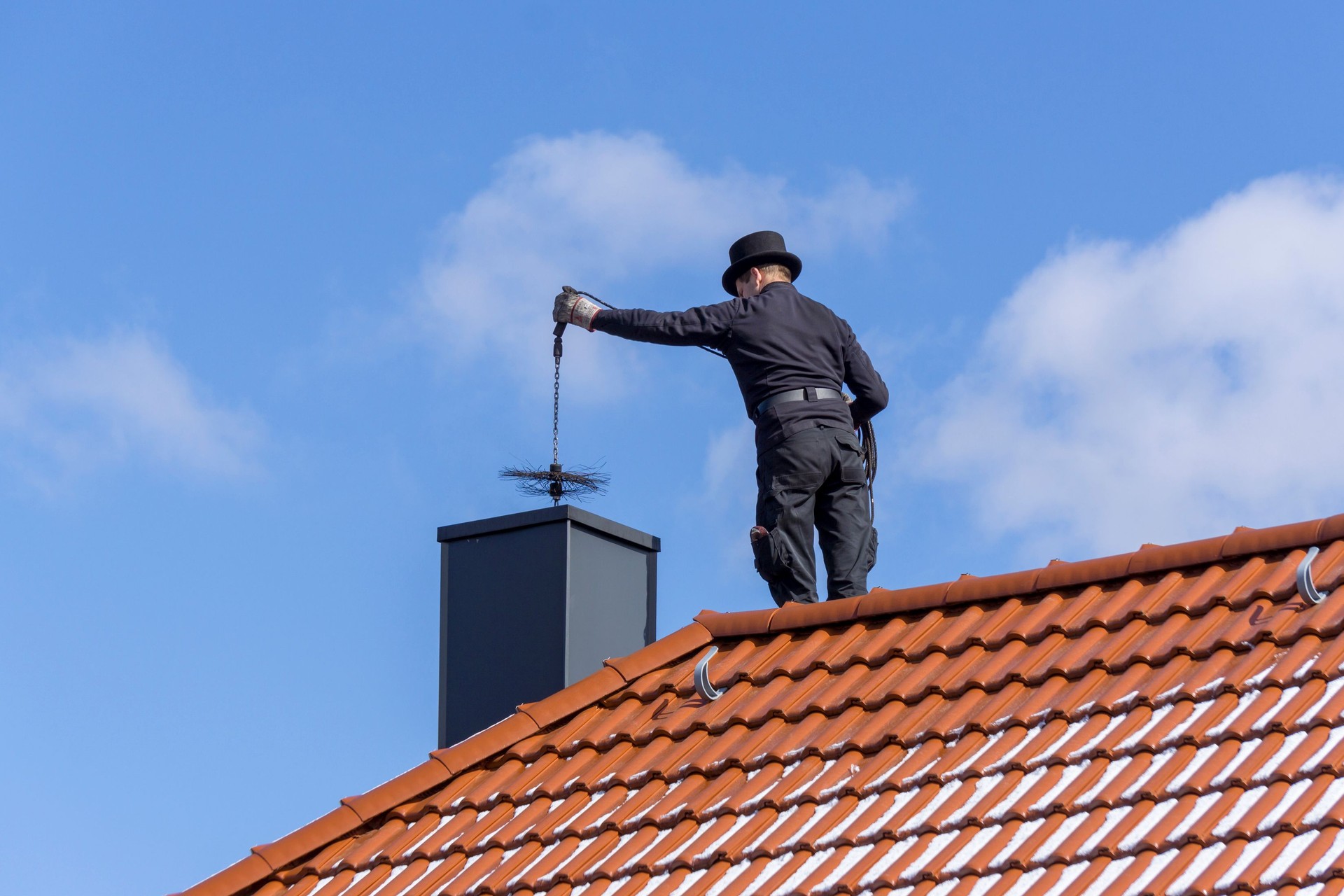 Chimney sweep cleans the chimney during the annual maintenance. Chimney sweep cleans the chimney during the annual maintenance.